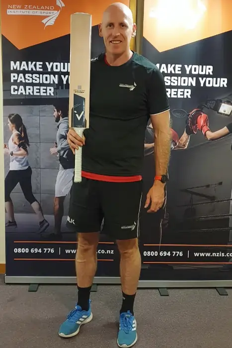 Cricketer with ANGLAR bat at NZ Institute of Sport, showcasing cricket accessories.