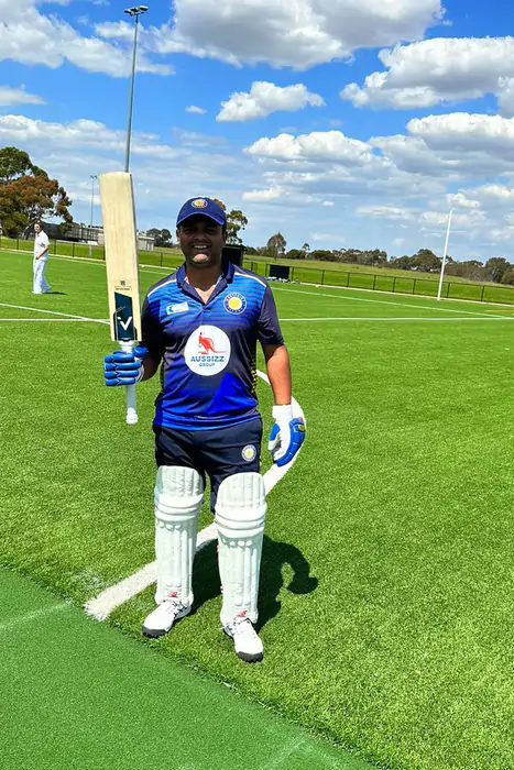 Cricketer with ANGLAR bat on field, showcasing cricket accessories